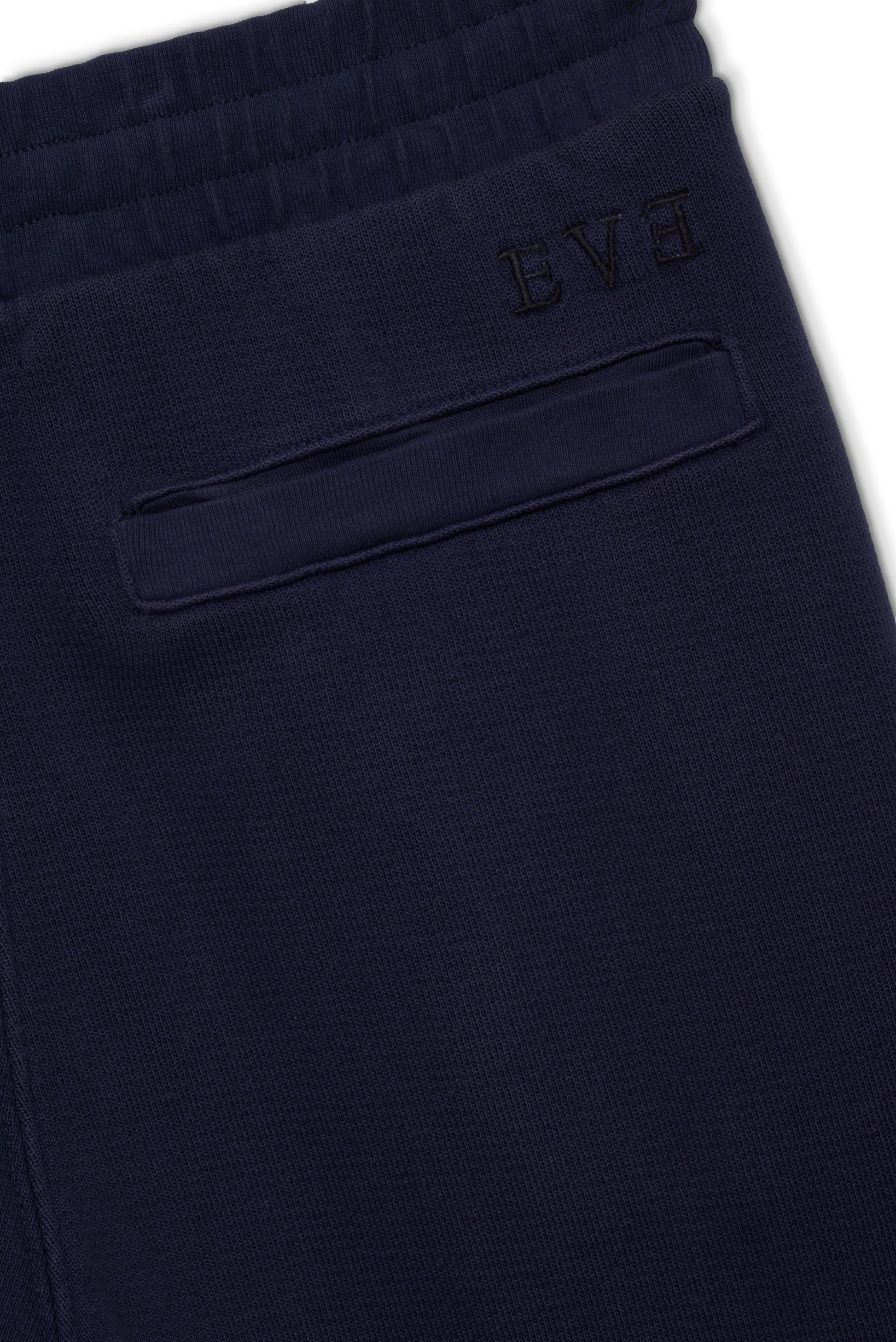 Close-up of navy brushed French terry jogger with embroidered logo and pocket detail.