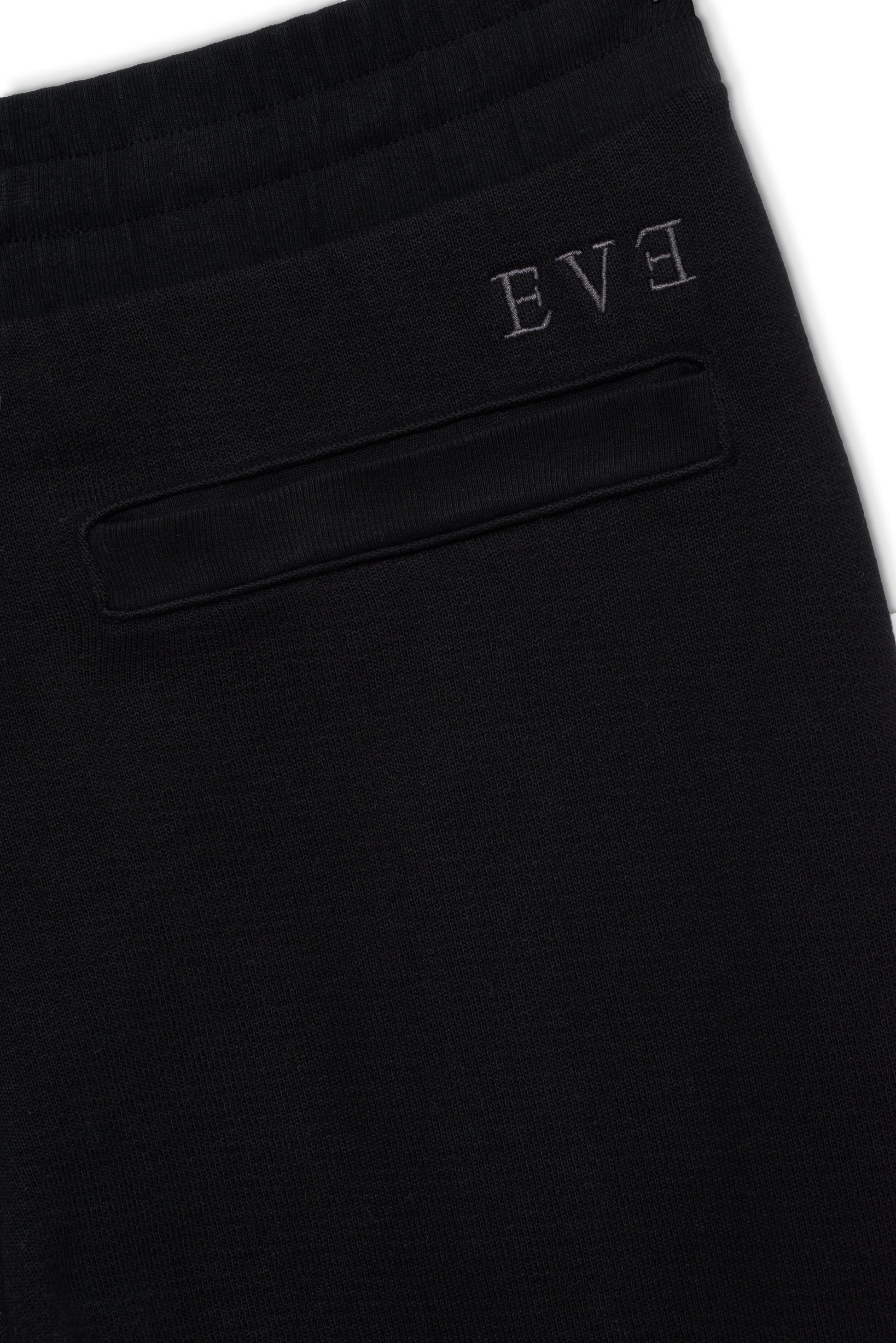 Close-up of black jogger with embroidered logo above back pocket, showcasing minimalist design and comfortable French terry fabric.